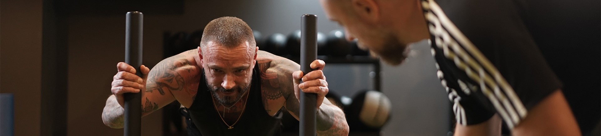 personal trainer encouraging client on the sled push.
