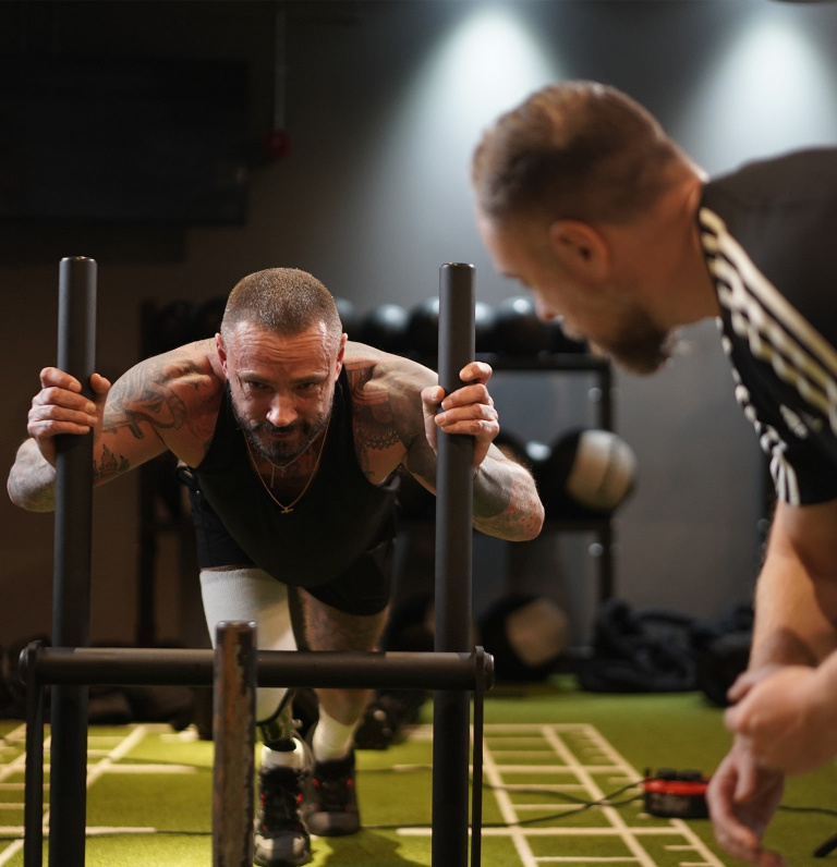 personal trainer encouraging client on the sled push.
